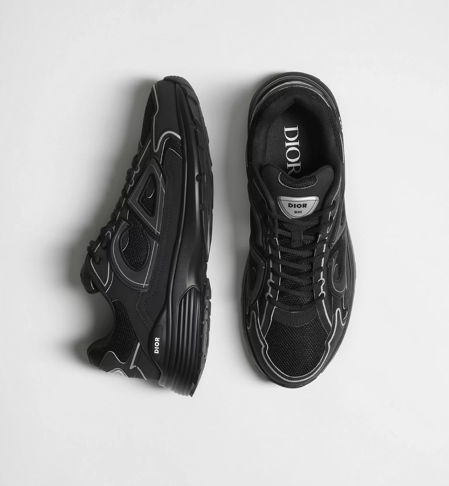 Black Dior B30 sneaker pair, side views with lace-up design and embossed logo