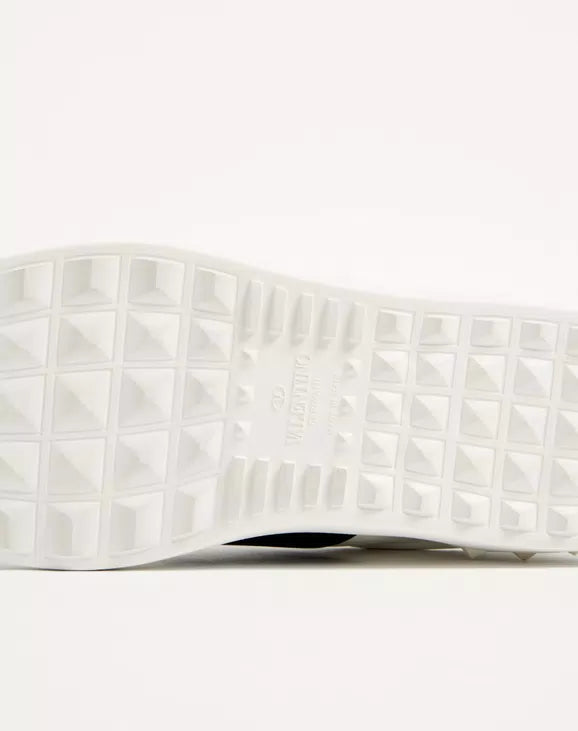 Calfskin open sneaker outsole with white tread and textured cube pattern.