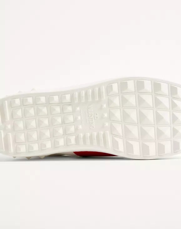 White studded rubber outsole underside with red edge trim.