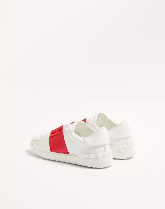 White open sneaker with red side panel and lace-up; padded heel collar.