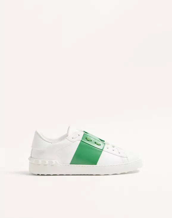 White open sneaker with green center panel, lace-up front, contrast stitching.