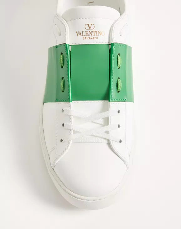 White sneaker tongue with 'VALENTINO GARAVANI' text, green straps, lace-up front.