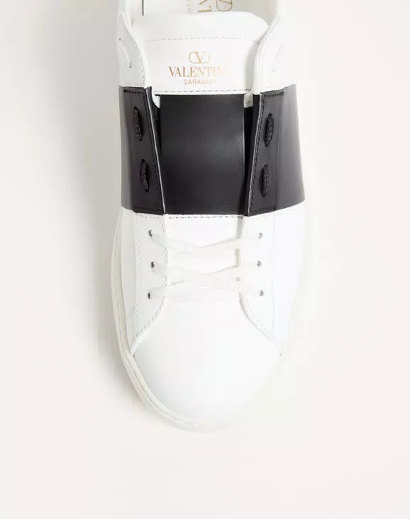Calfskin sneaker close-up with VALENTINA logo, white leather and black heel strap.