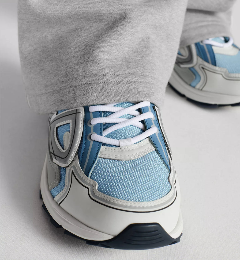 Rear side close-up of Dior B30 countdown sneaker with light blue upper and rubber sole.