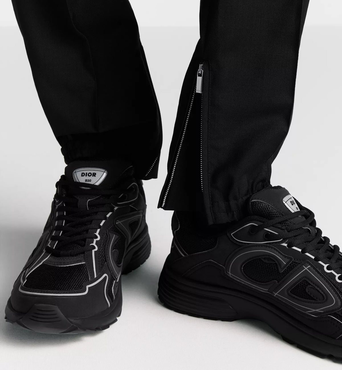 Black Dior B30 sneakers worn with black pants, lace-up with chunky sole