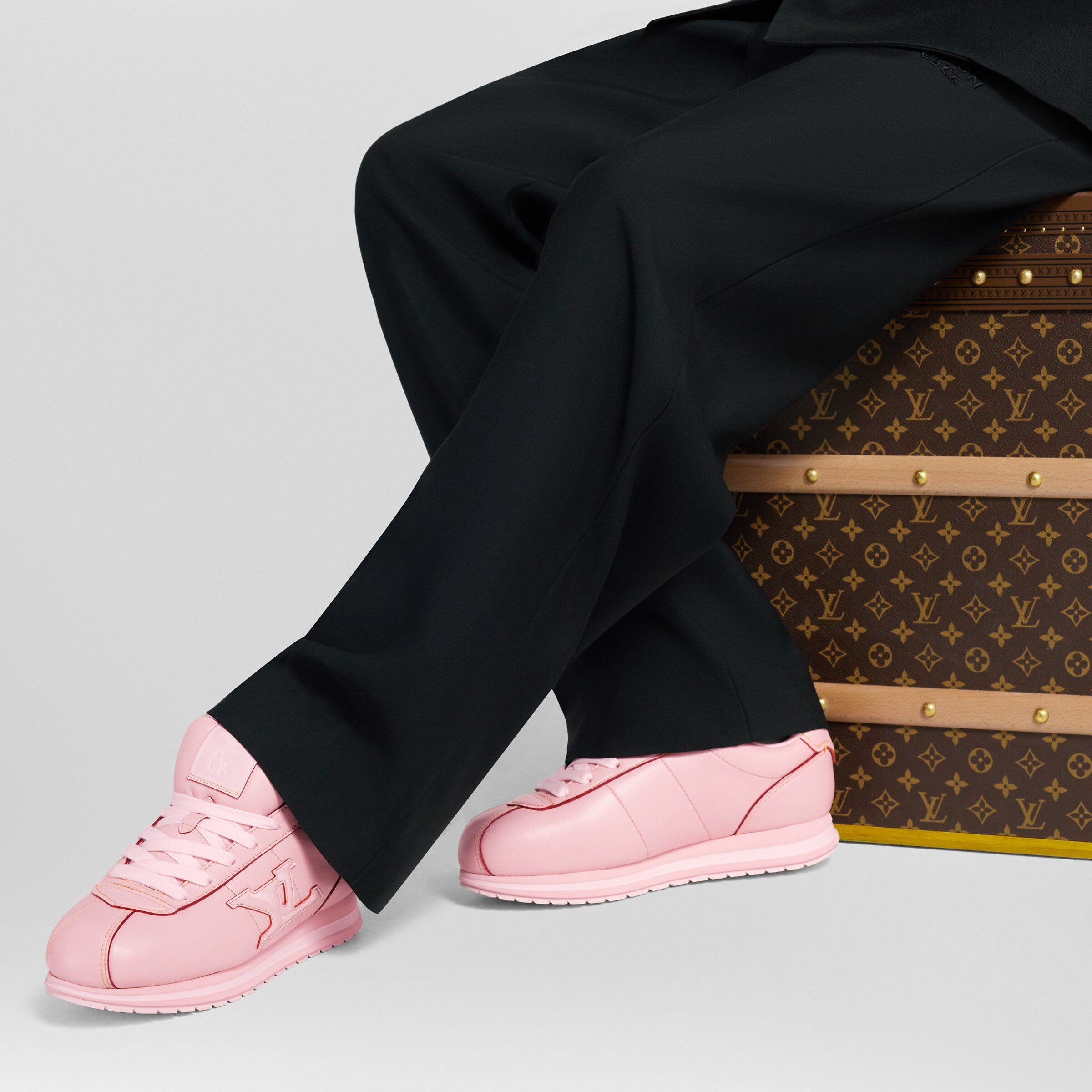 Pink lace-up sneakers worn with black pants; low platform rubber sole