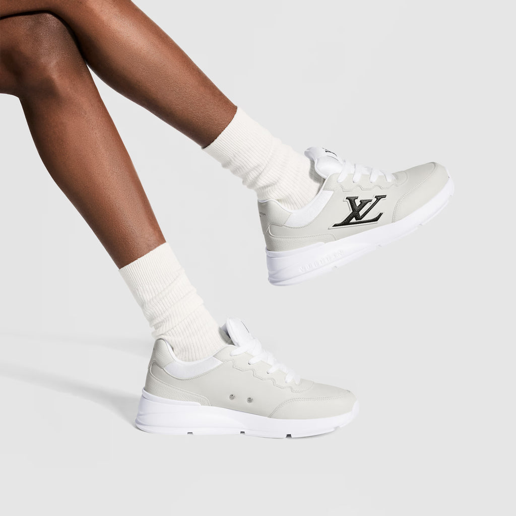 White LV logo sneakers on model, lace-up style with low profile rubber sole