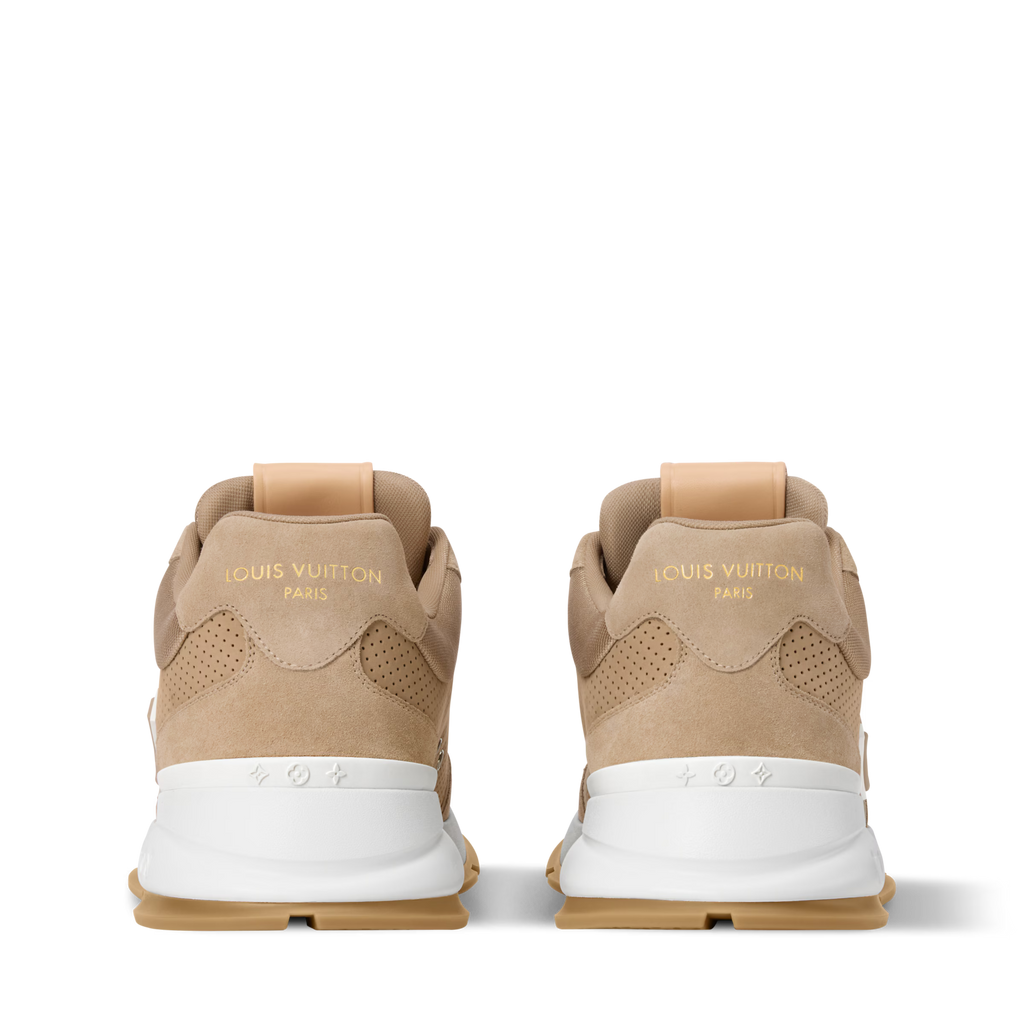 Beige sneakers shown from heel with branding and perforated side panels