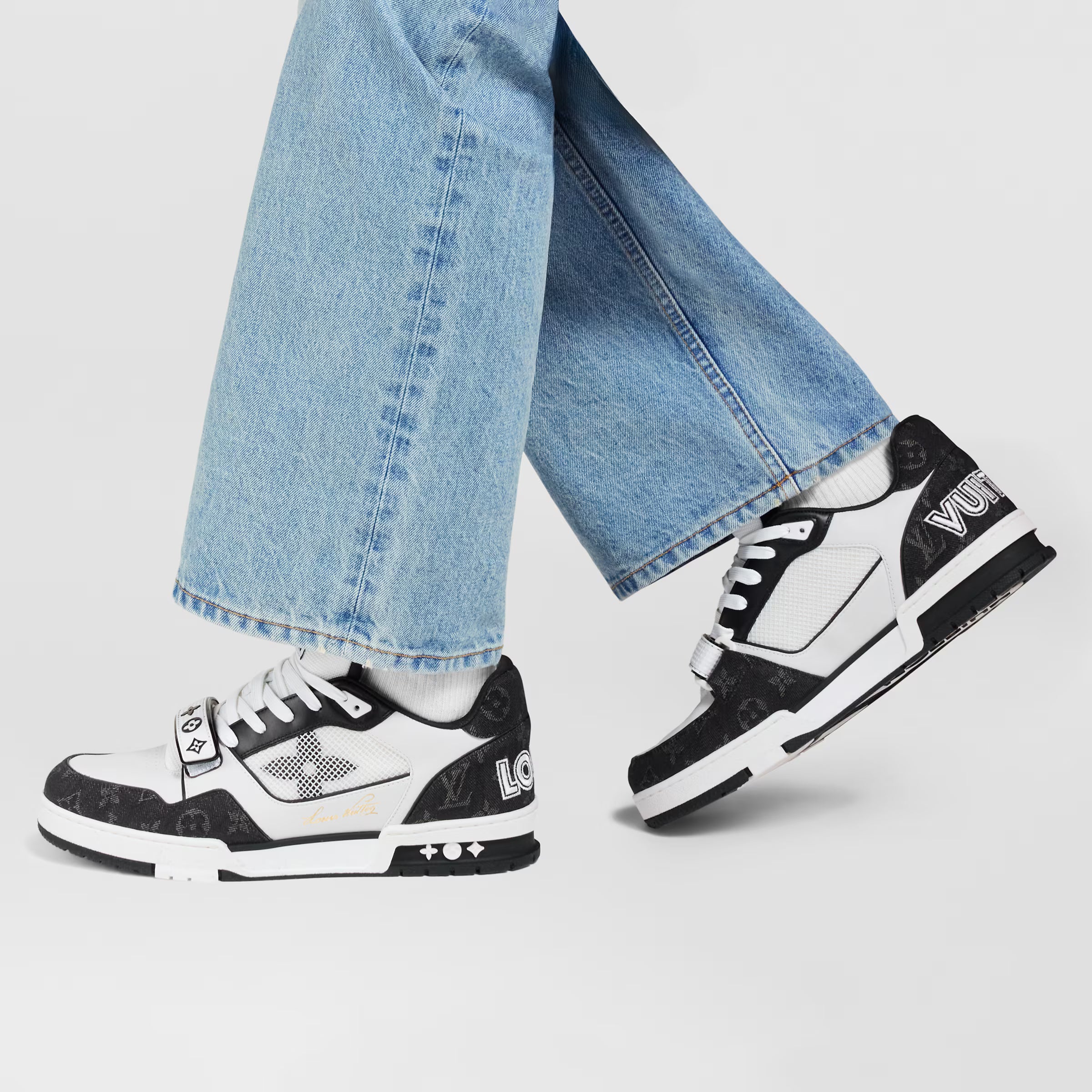 LV Trainer sneakers worn with light-wash jeans, white-and-black lace-up design