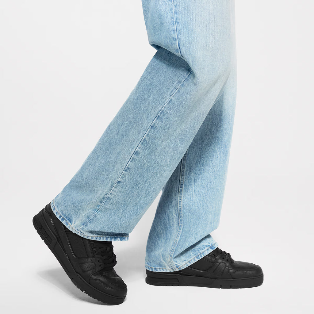 Black LV Trainer sneakers worn with light blue jeans, lace-up low tops