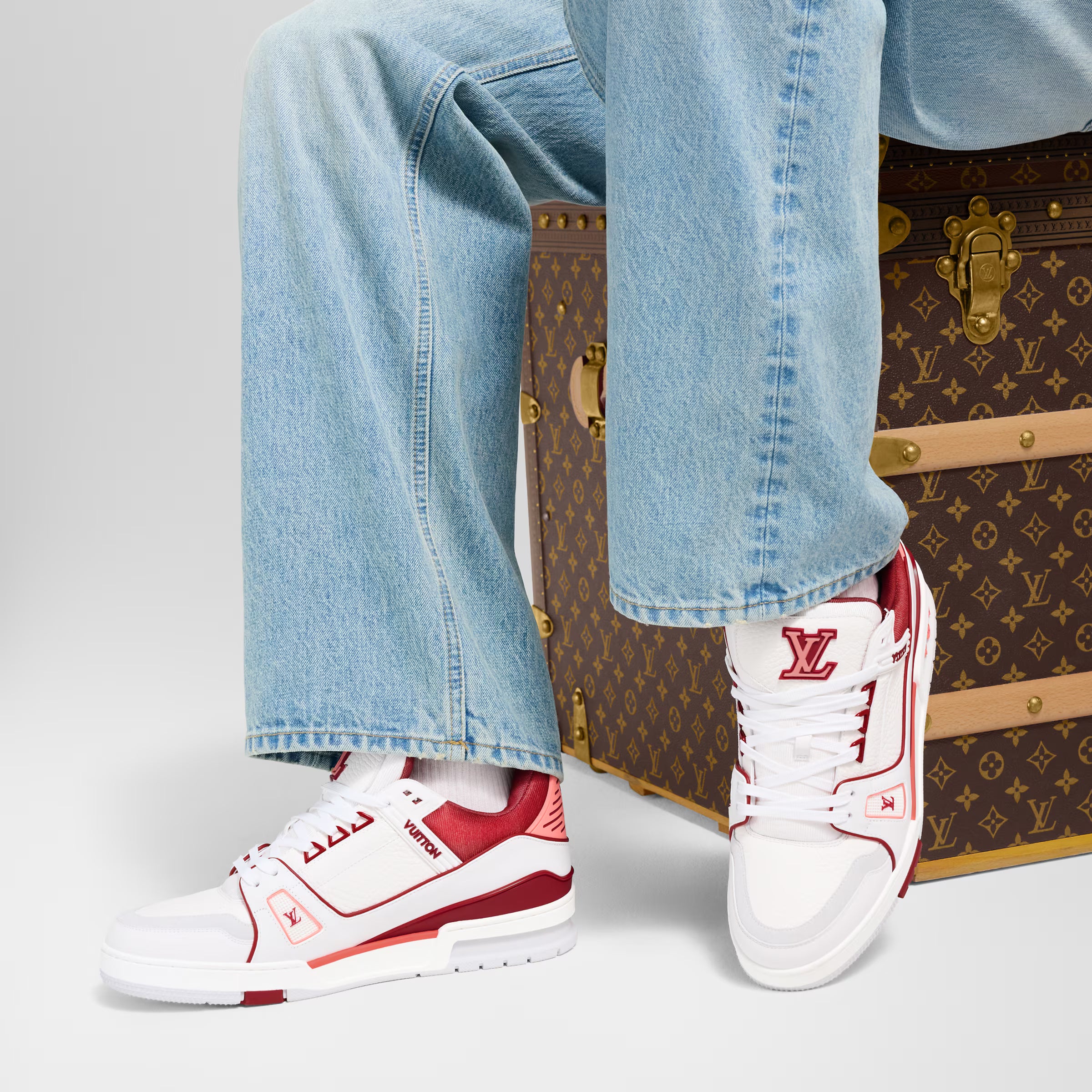 White and red LV low-top sneakers worn with light-wash jeans