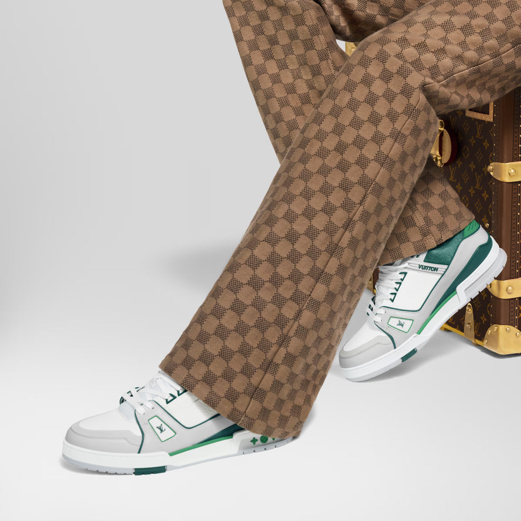 White and green low-top sneakers worn with tan check pants
