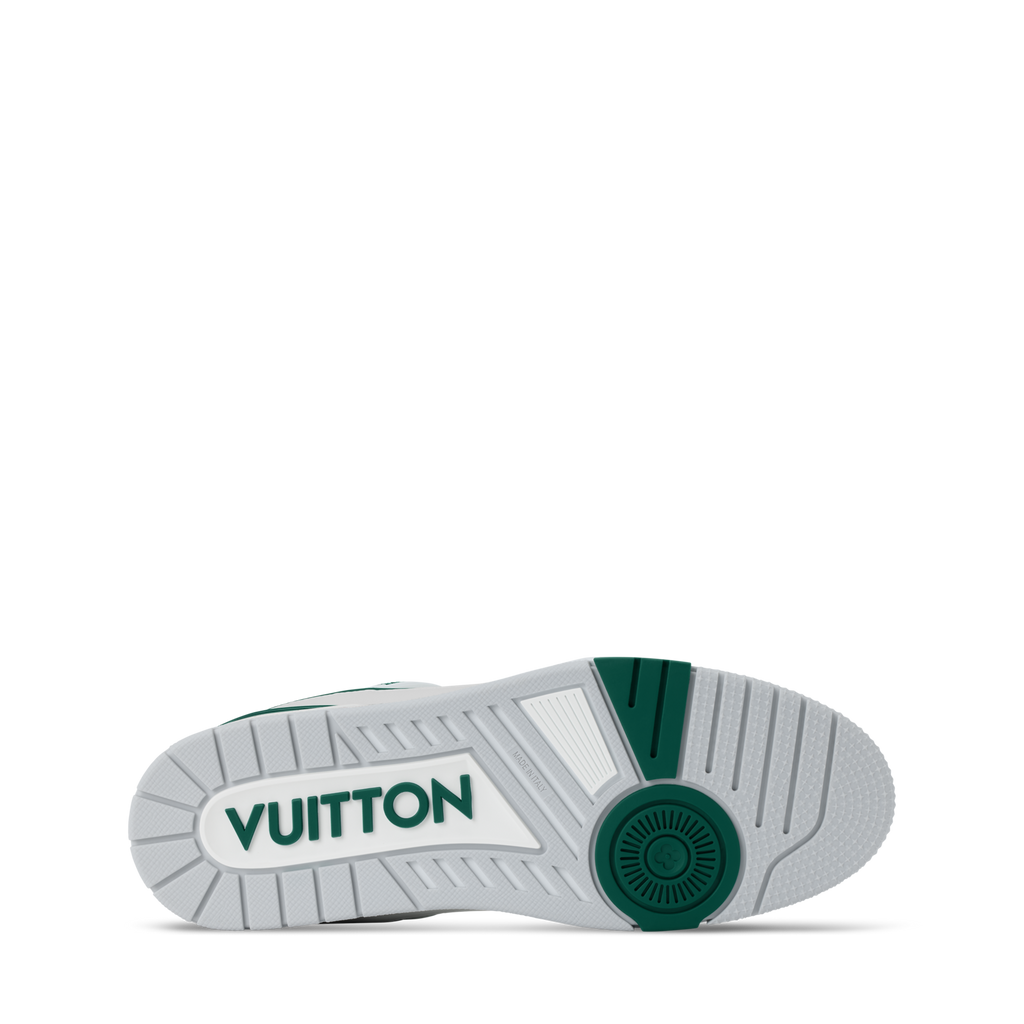 Outsole view of white low-top sneakers with green logo and tread