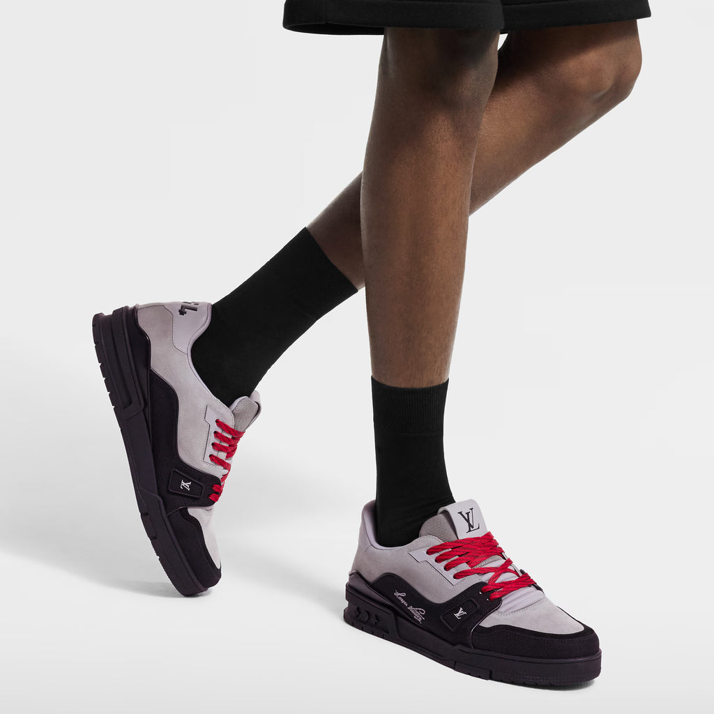 Sneakers with red laces worn with black socks and dark trousers