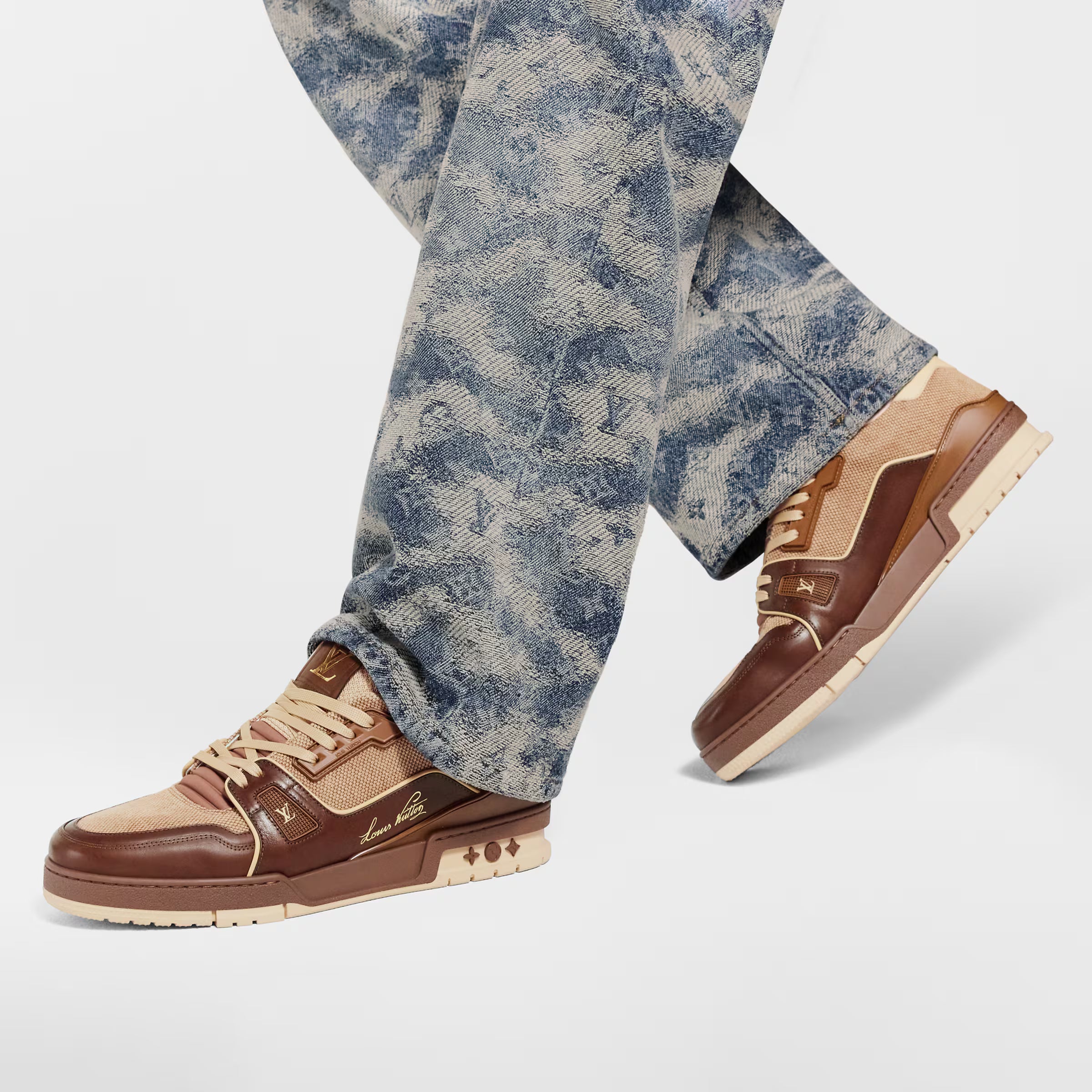 LV Trainer sneaker worn with blue patterned jeans; dark brown and tan lace-up design