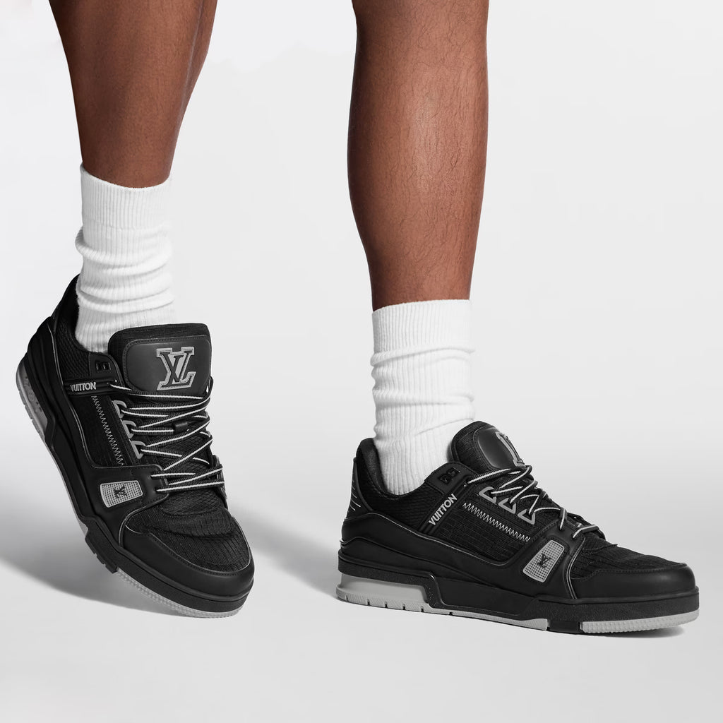 Black LV Trainer distressed sneaker on feet with white socks, lace-up and chunky sole
