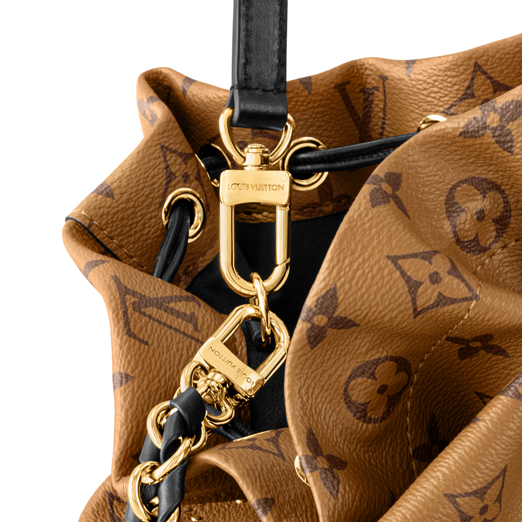 Gold-tone hardware close-up on monogram bucket bag with black strap and ring